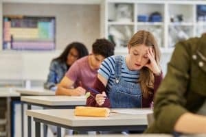 Studente houdt hoofd vast tijdens examen op middelbare school
