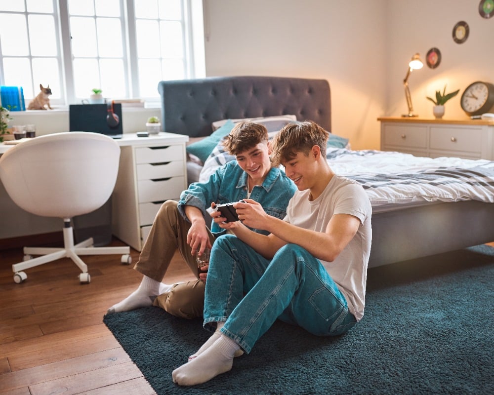 Twee jongens spelen samen een spel op telefoon