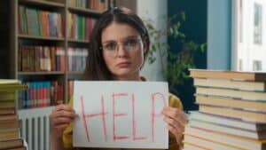 Lerares met bordje in handen waar help op staat