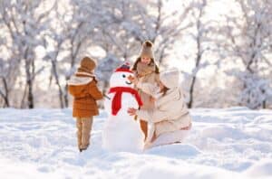 twee kinderen maken sneeuwpop in de sneeuw