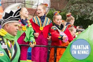 Zingende kinderen op een carnavalswagen in een optocht