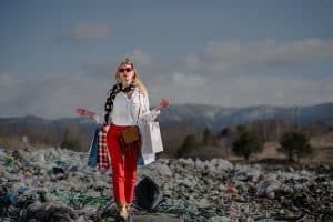 Vrouw met kleding op vuilnisbelt