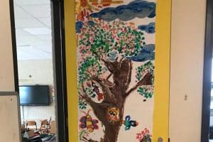 Een groot voorjaarsschilderij op de deur van een klaslokaal