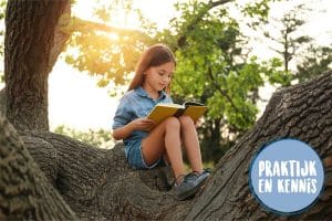 Meisje dat een boek leest in een boom