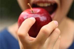 Een vrouw bijt in een appel