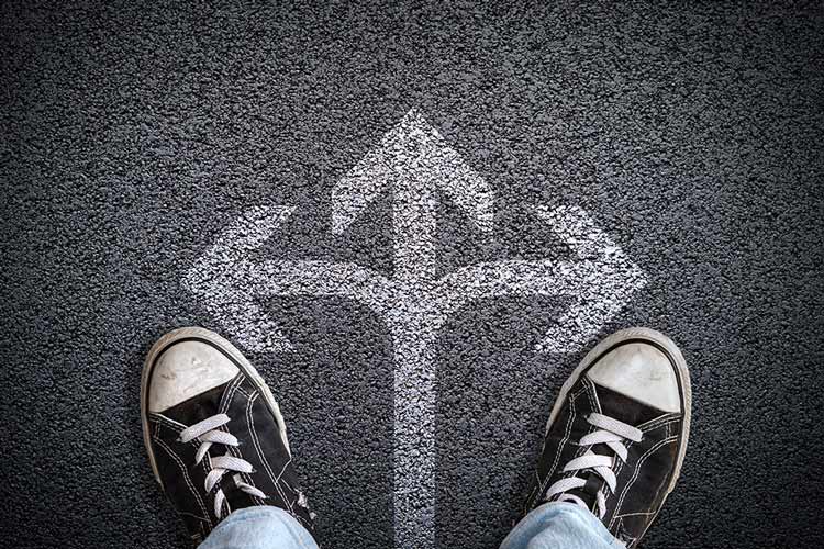 Twee schoenen die op een weg staan met pijlen in verschillende richtingen