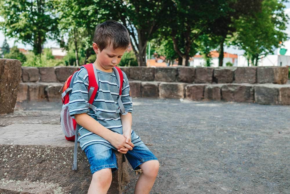 Een verdrietige kleuter op het schoolplein