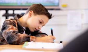 Jongen schijft in een schrift