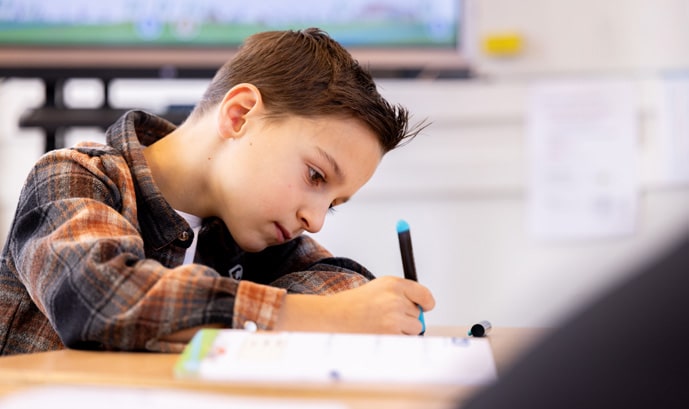 Jongen schijft in een schrift