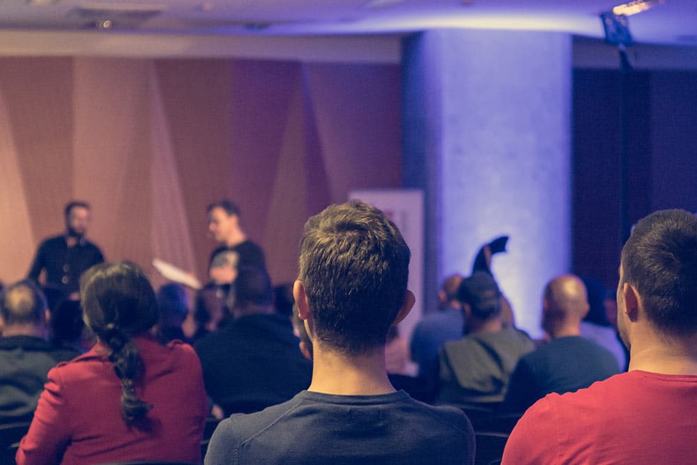 Jongeren bekijken een onderwijsdebat vanuit de zaal