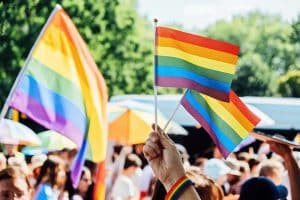 Jongeren zwaaien met regenboogvlaggen