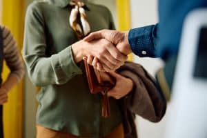 Een ouder en leerkracht schudden elkaar de hand