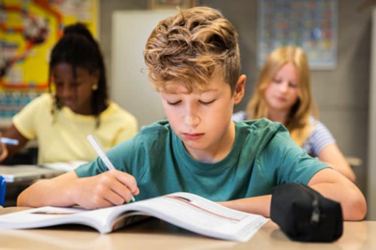 Een leerling schrijft in een leerwerkboek