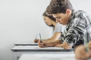 Een schrijvende jongen in de klas