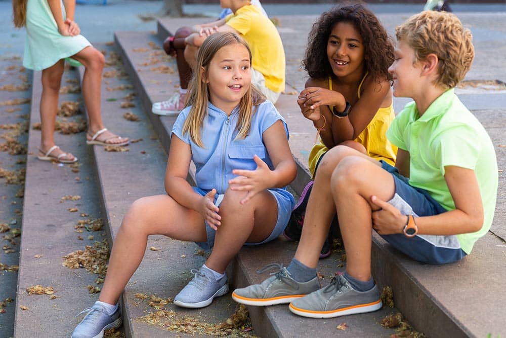 Drie kinderen praten met elkaar in jongerentaal