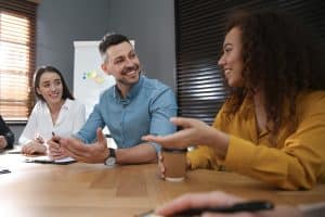 Drie leerkrachten overleggen aan een tafel over kwaliteitsverbetering op school
