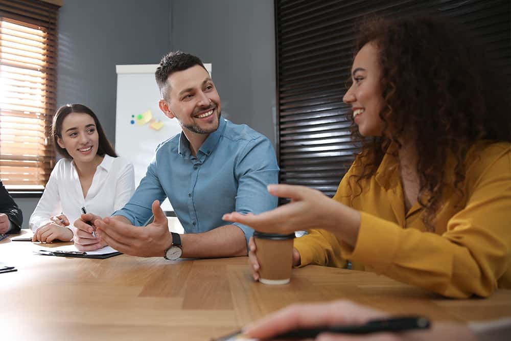 Drie leerkrachten overleggen aan een tafel over kwaliteitsverbetering op school