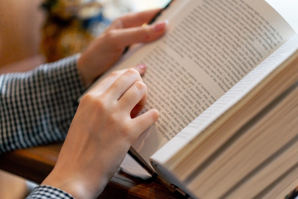 Een leerling leest een boek tijdens de les