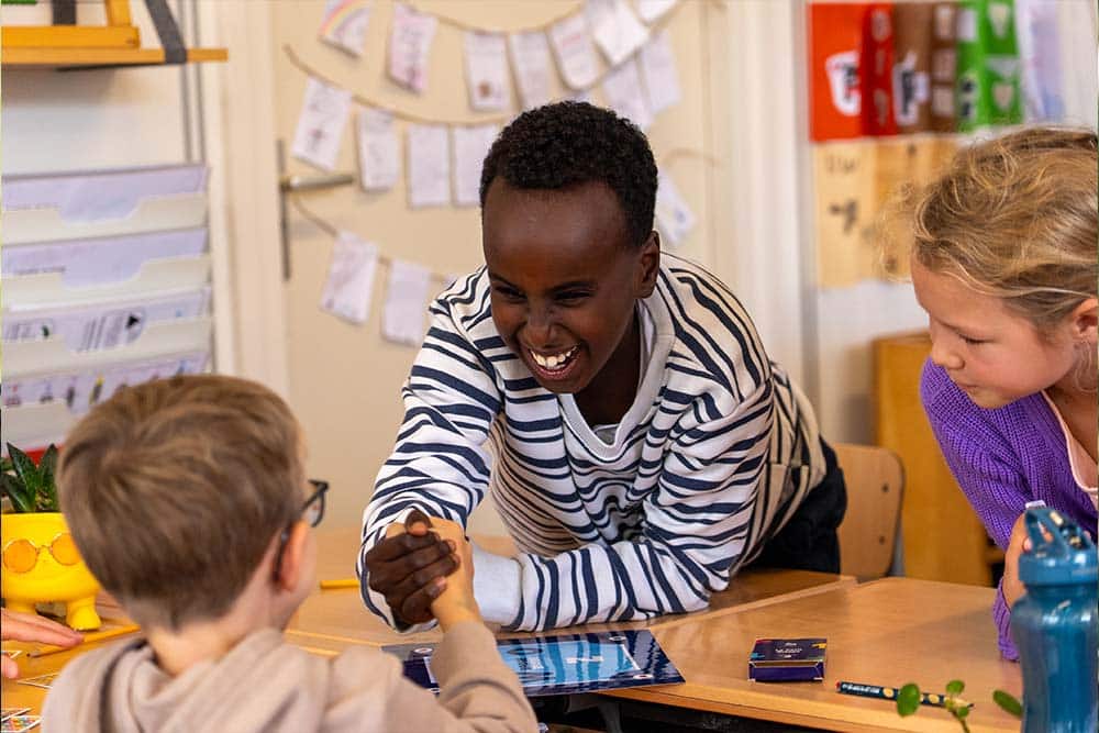 Vier kinderen spelen enthousiast bridge op school