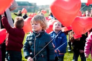 Kinderen hebben ballonnen in de vorm van hartjes in hun hand