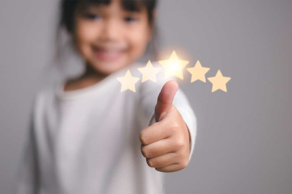 Een kind steekt haar duim op en geeft 5 sterren