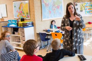 Een leerkracht laat en tampon zien en voert een gesprek met de kinderen uit haar klas