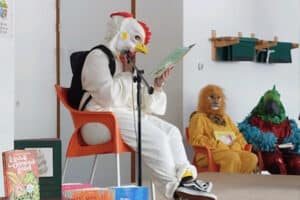 Een kip leest voor tijdens The masked reader op school