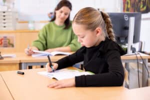 Een kind schrijft in een werkboek