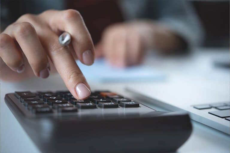 Een vrouw typt op een rekenmachine