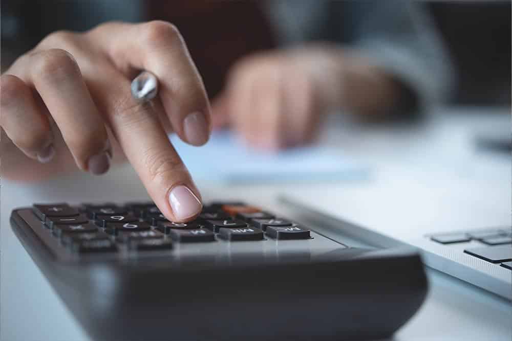 Een vrouw typt op een rekenmachine