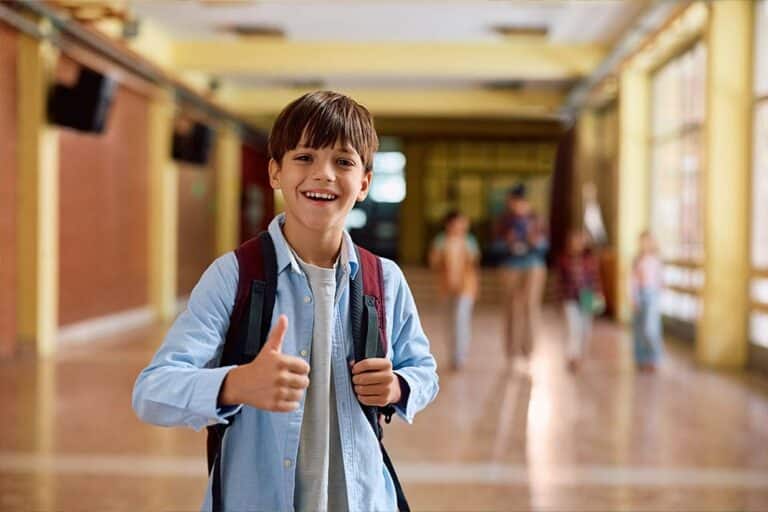 Een leerling steekt zijn duim op in de gang