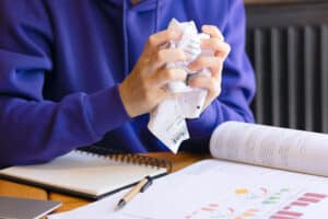 Een student met een prop papier in zijn handen