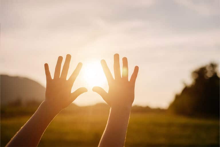 Een kind rijkt naar de zon