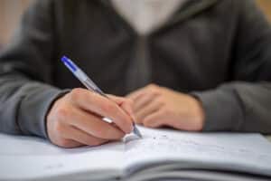 Een leerling schrijft een samenvatting ter voorbereiding op zijn examen