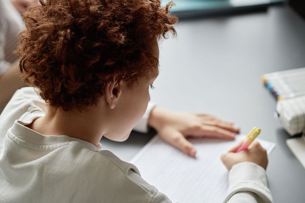 Een kind schrijft met een pen