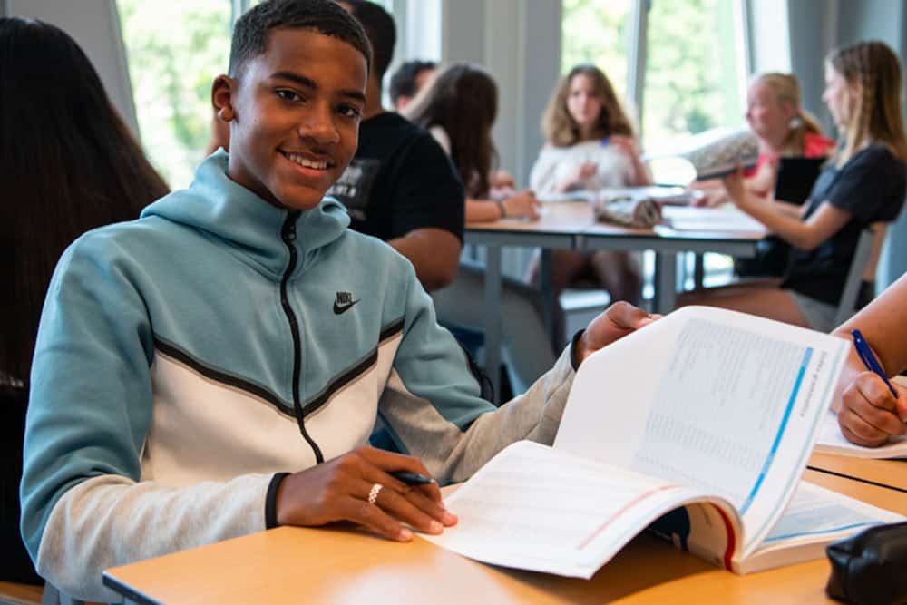 Een leerling is in de klas aan het werk