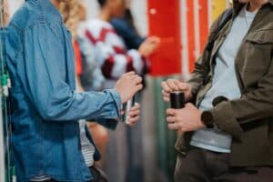 Twee studenten drinken een blik energydrink in de examenperiode op het mbo