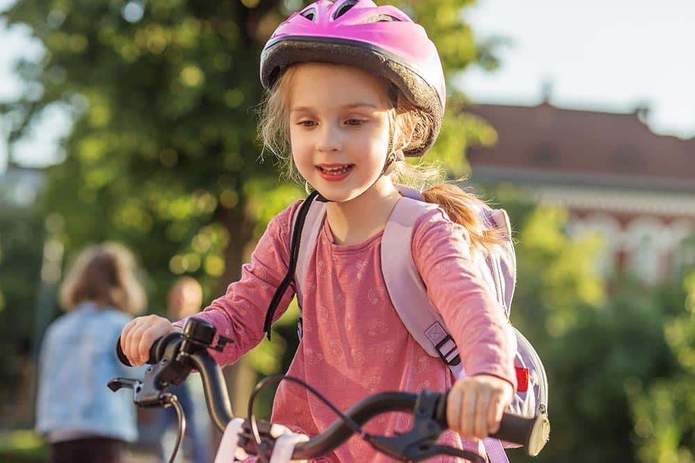 Een jong kind fietst naar school