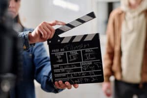 jongeren met een filmklapper in hun hand, ze werken aan filmeducatie