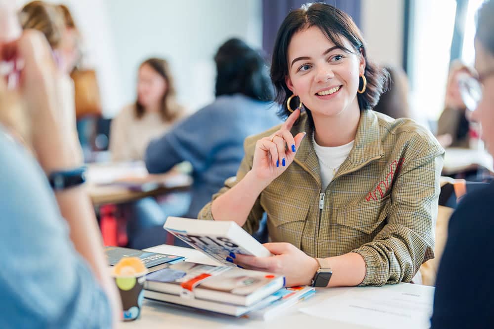 Een groepje leerlingen praat over een boek tijdens een leesclub op school