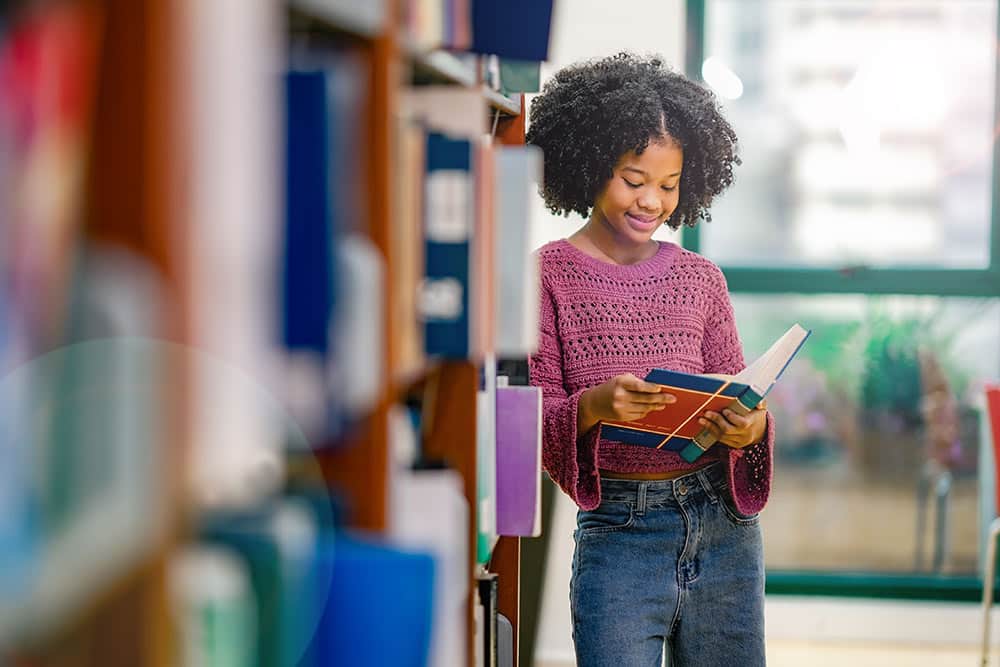 Een kind staat in de schoolbibliotheek