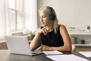 Een vrouw kijkt naar een webinar op haar laptop