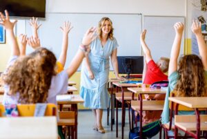 Kinderen steken hun handen in de lucht tijdens de dagopening